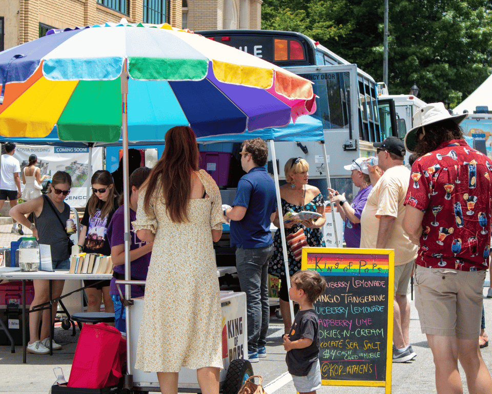 People gathered outside the King of Pops stand at KidsFest at AthFest 2024.