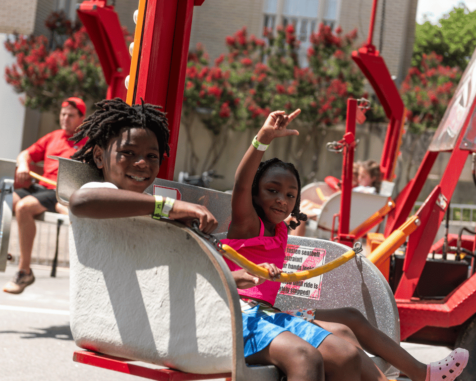 Two kids on a ride at KidsFest at AthFest 2024.