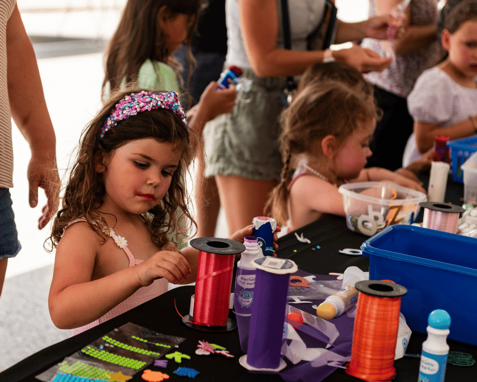 A girl holds ribbon at KidsFest at AthFest 2024.